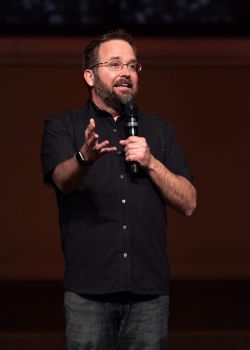 Profile of a man wearing glasses and a suit