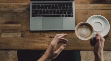 Computer and coffee on table